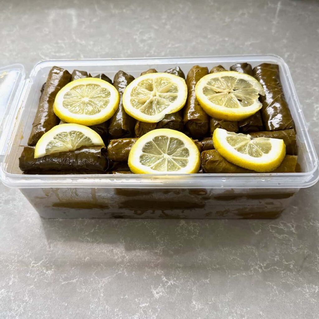 Kutuda zeytinyağlı yaprak sarması ve limon dilimleri